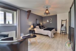 um quarto com uma cama, uma mesa e uma cadeira em La ville lesne em Montauban-de-Bretagne