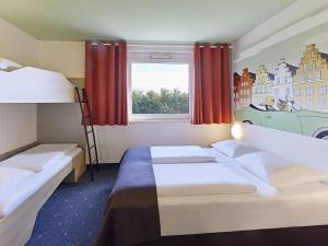 1 Schlafzimmer mit 2 Etagenbetten und einem Fenster in der Unterkunft B&B Hotel Osnabrück in Osnabrück
