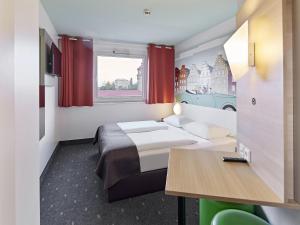 um quarto de hotel com uma cama e uma mesa em B&B Hotel Osnabrück em Osnabrück