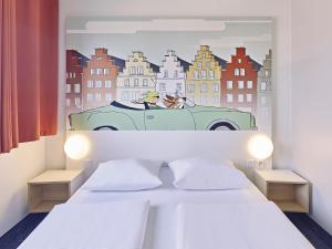 a bedroom with a painting of a dog in a car at B&B Hotel Osnabrück in Osnabrück