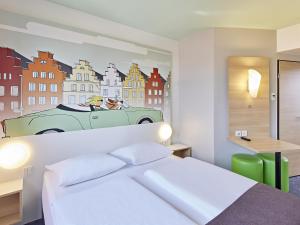 a bedroom with a bed and a painting of a car at B&B Hotel Osnabrück in Osnabrück