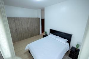 um quarto com uma cama branca e uma janela em Apartment at Pearl Marina - Garuga Road em Wakiso