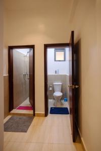 uma casa de banho com um WC e uma cabina de duche ao nível do chão em Apartment at Pearl Marina - Garuga Road em Wakiso