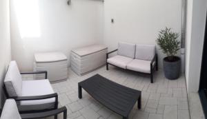 una sala de estar con muebles blancos y una maceta. en Gite Le Petit Malsbach Eguisheim, en Eguisheim