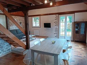 een woonkamer met een tafel en stoelen bij Domaine de karoli in Barneville-sur-Seine