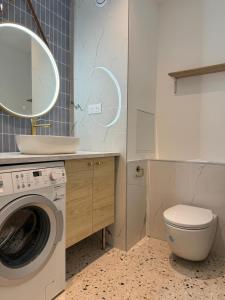 ein Badezimmer mit einer Waschmaschine und einem Waschbecken in der Unterkunft Paris La Belle in Paris