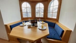 una sala da pranzo con tavolo in legno e sedie blu di 250m zur Hannigalp und Bergpanorama a Grächen
