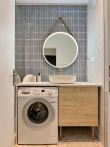 ein Badezimmer mit einer Waschmaschine und einem Spiegel in der Unterkunft Paris La Belle in Paris