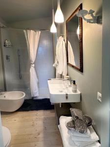 ein Badezimmer mit einem Waschbecken, einer Badewanne und einem Spiegel in der Unterkunft La casa di Zoe-ARTANDTRAVEL in Montefiascone