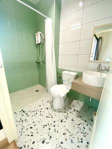 ein Bad mit einem WC, einem Waschbecken und einer Dusche in der Unterkunft House 945 in Khon Kaen
