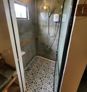 a bathroom with a shower with a glass door at Tarzan's House in General Luna