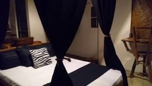 a bed with black curtains in a room at Tarzan's House in General Luna