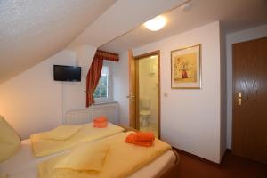 a bedroom with two beds with orange towels on them at Wolfsgrunder Festhof in Dorfchemnitz
