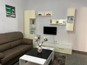 - un salon avec un canapé et une table fleurie dans l'établissement Apartamento Teresa, à Cambados