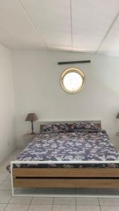 a bedroom with a bed with a round window at Montaigu Plage in Montaigu-de-Quercy