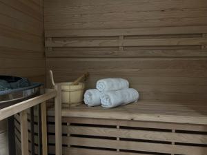 een stapel handdoeken op een plank in een sauna bij Parkcity Katowice Bogucice in Katowice