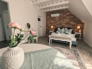 uma sala de estar com uma cama e um vaso com flores em Elisoria Superiors em Cserszegtomaj