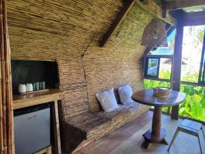 a room with a brick wall with a table and a tv at Tarzan's House in General Luna