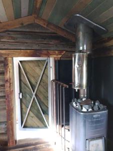a stove in a room with a wooden ceiling at Tiny House in Nattavaara by in Nattavaara