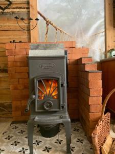 a wood stove in front of a stack of bricks at Tiny House in Nattavaara by in Nattavaara
