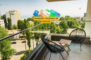 a balcony with two chairs and a table at Diamond View Apartments in Mamaia