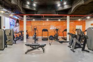 a gym with several treadmills and other exercise equipment at Mövenpick Hotel Mansour Eddahbi Marrakech in Marrakesh