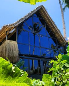 a blue house with a straw roof at Tarzan's House in General Luna