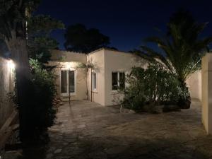 a white house with a palm tree at night at Loustalou in Saint-Tropez