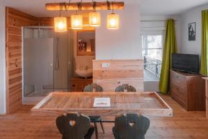 sala de estar con mesa de madera y sillas en Hostel - Ron`s Guesthouse en Oberstdorf