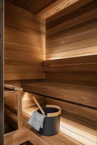 uma sauna com um balde preto e utensílios de madeira em Original Sokos Hotel Puijonsarvi em Kuopio