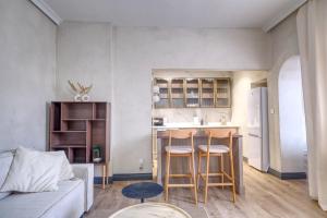 a living room with a couch and a kitchen at Apartament Gris in Sopot