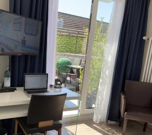 een bureau met een computer en een raam bij Stadt Hotel Marktheidenfeld in Marktheidenfeld