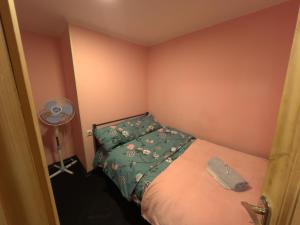 - une petite chambre avec un lit et un ventilateur dans l'établissement Aghmashenebeli Apartment, à Tbilissi