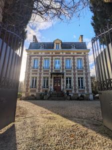 a large house with a gate in front of it at Le Domaine des Prés du Hom in Bézu-Saint-Éloi