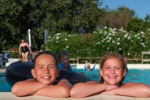 dos chicas tumbadas en una balsa en una piscina en Tenuta Tredici Ulivi, en Casa Albonetti
