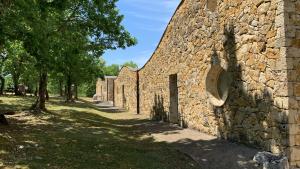 a stone wall with a pathway next to a building at Montaigu Plage in Montaigu-de-Quercy
