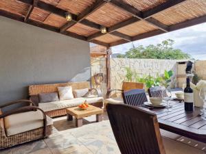 a patio with a couch and a table and chairs at MEDANO4YOU Montaña Roja Beach House in El Médano