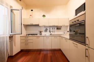 eine Küche mit weißen Schränken und Holzböden in der Unterkunft Suite Amendola-Luxury apartment in Bari