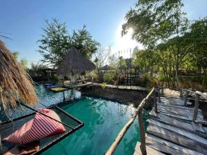 - une piscine dans un complexe avec un hamac dans l'établissement บุญพน รีสอร์ต Maldives resort&restaurant, à Wichian Buri