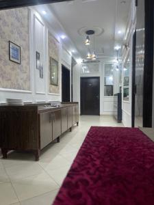 una grande stanza con un tappeto rosso sul pavimento di Hotel Tulip Inn, Gulberg a Lahore