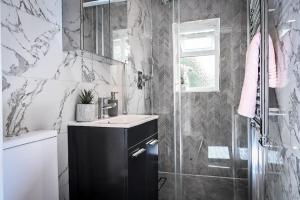 a bathroom with a sink and a shower at Jazzy 2BR Enfield Crib - Parking, Wi-Fi & Private Garden in Ponders End