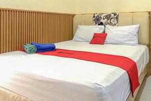 una camera con due letti con cuscini rossi e blu di RedDoorz near Wisma Cahaya Abadi Sepinggan Aiport a Balikpapan