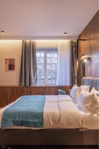 a bedroom with a large bed and a window at Hotel Square by MARGO in Pristina