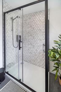 a shower with a glass door in a bathroom at The Burrow in Sion Mills