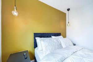 a bedroom with a white bed and a yellow wall at The Burrow in Sion Mills +42 photos