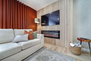 a living room with a white couch and a tv at The Burrow in Sion Mills