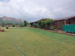 een grote tuin naast een huis met een hek bij Gramya Resort in Alwar