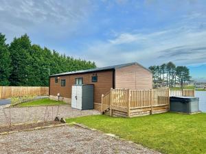 una pequeña casa con una valla de madera y un patio en Luxury Langham Lodge, en Clitheroe