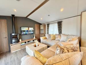 a living room with two couches and a tv at Luxury Langham Lodge in Clitheroe