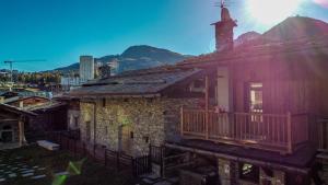 an old stone building with a porch and a church at Baita Plagnol Sestriere Ski Slopes in Sestriere